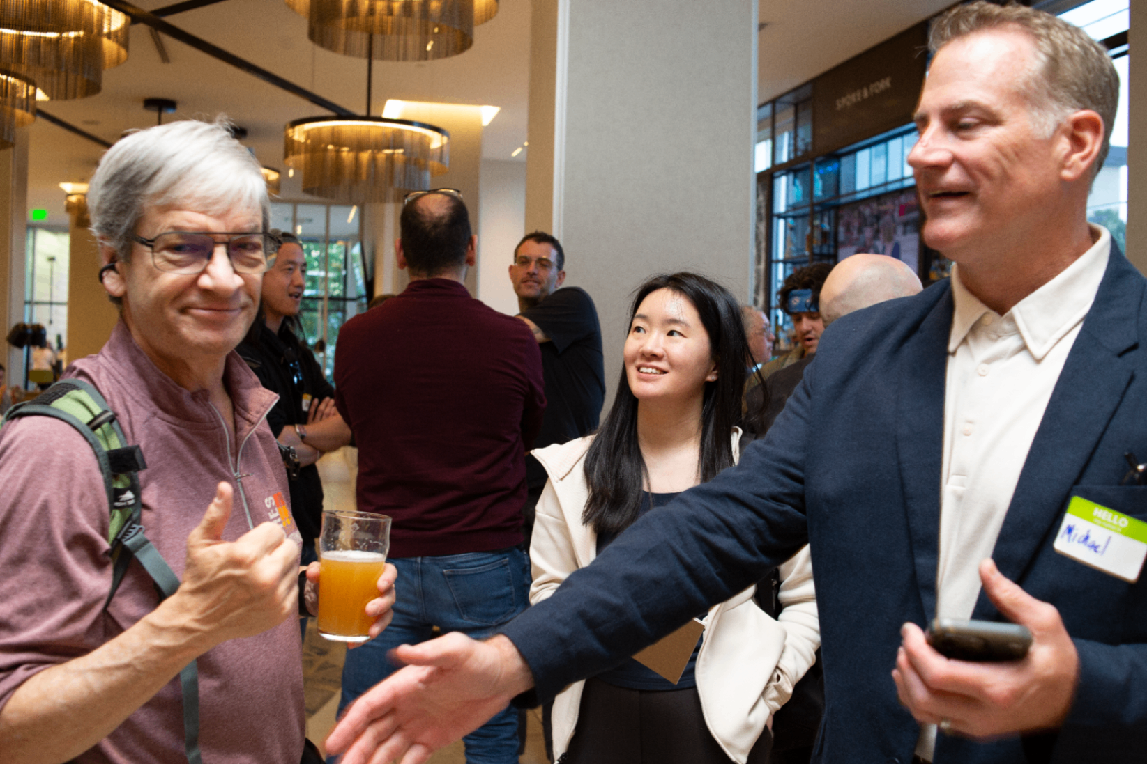 Founders networking in the event lobby with drinks in hand