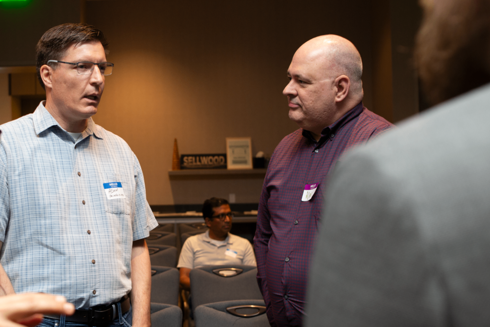 Two attendees talking between rows of seats