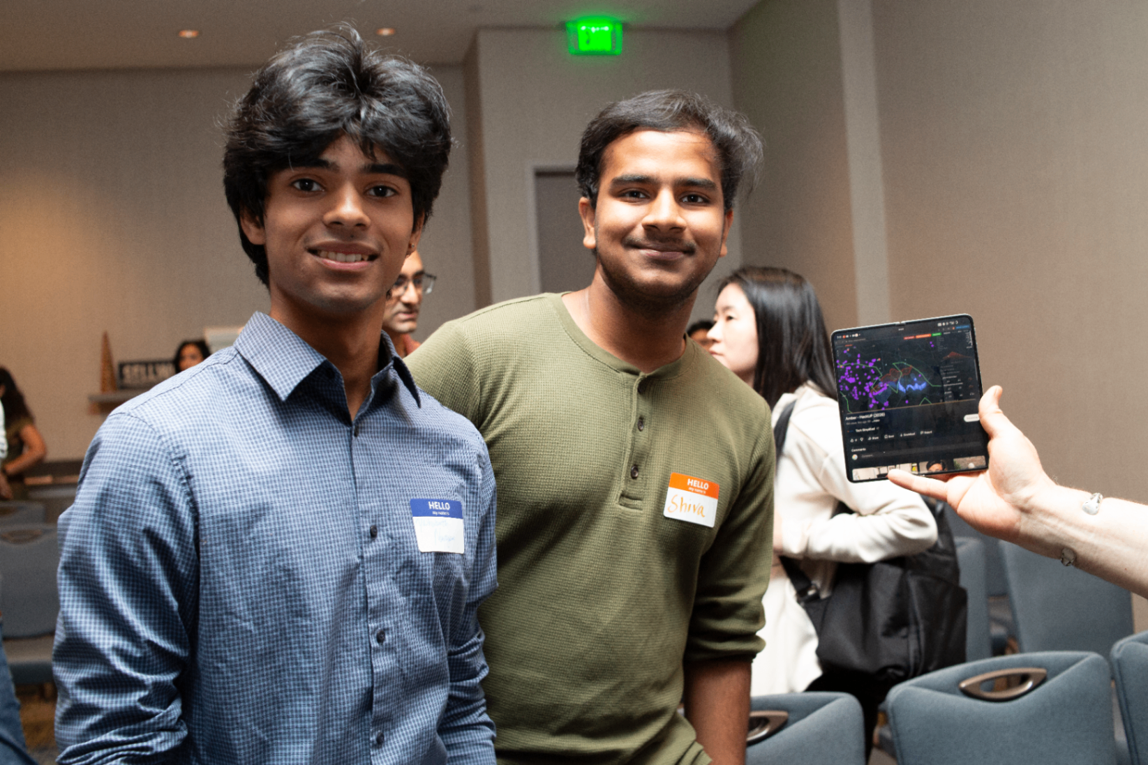 Two young founders posing with a tablet demo