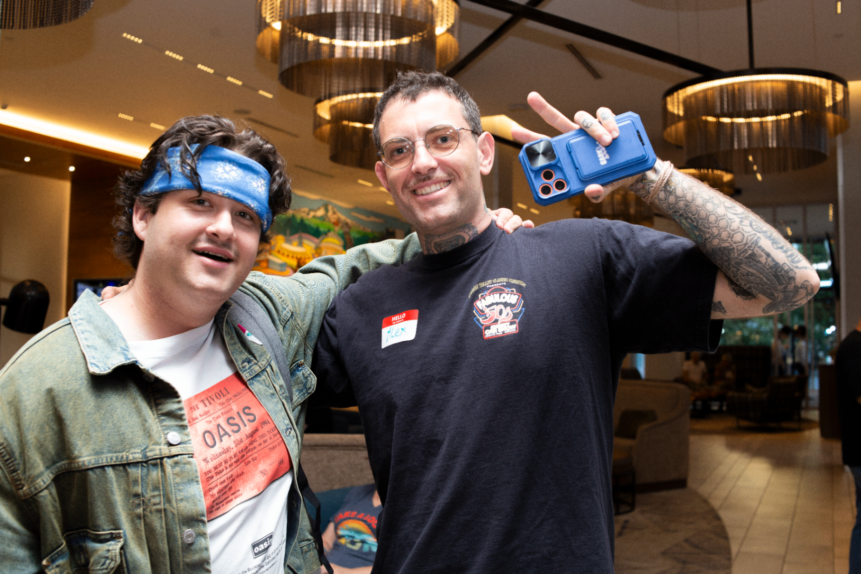 Two attendees posing together under warm lobby lights