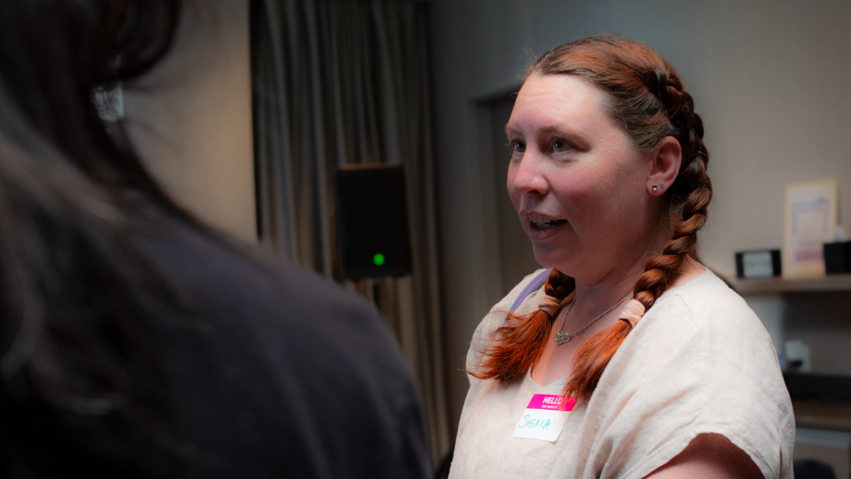 Attendee with braided hair in conversation at the meetup