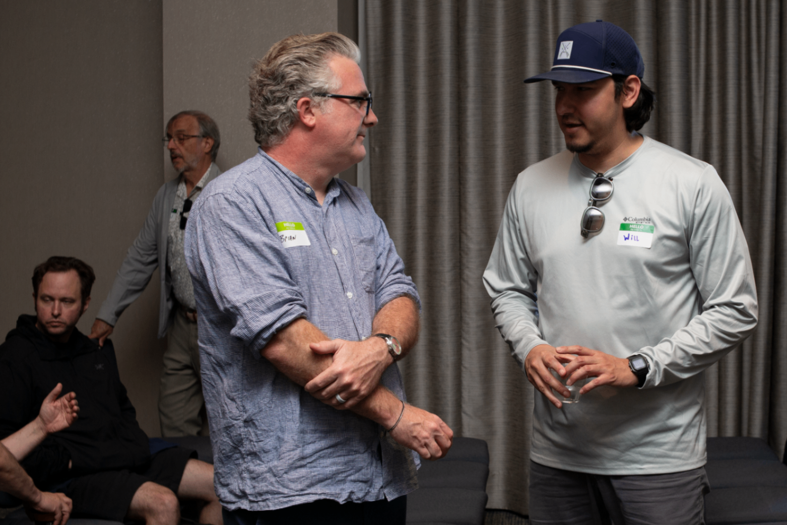 Two attendees talking beside the curtains during networking