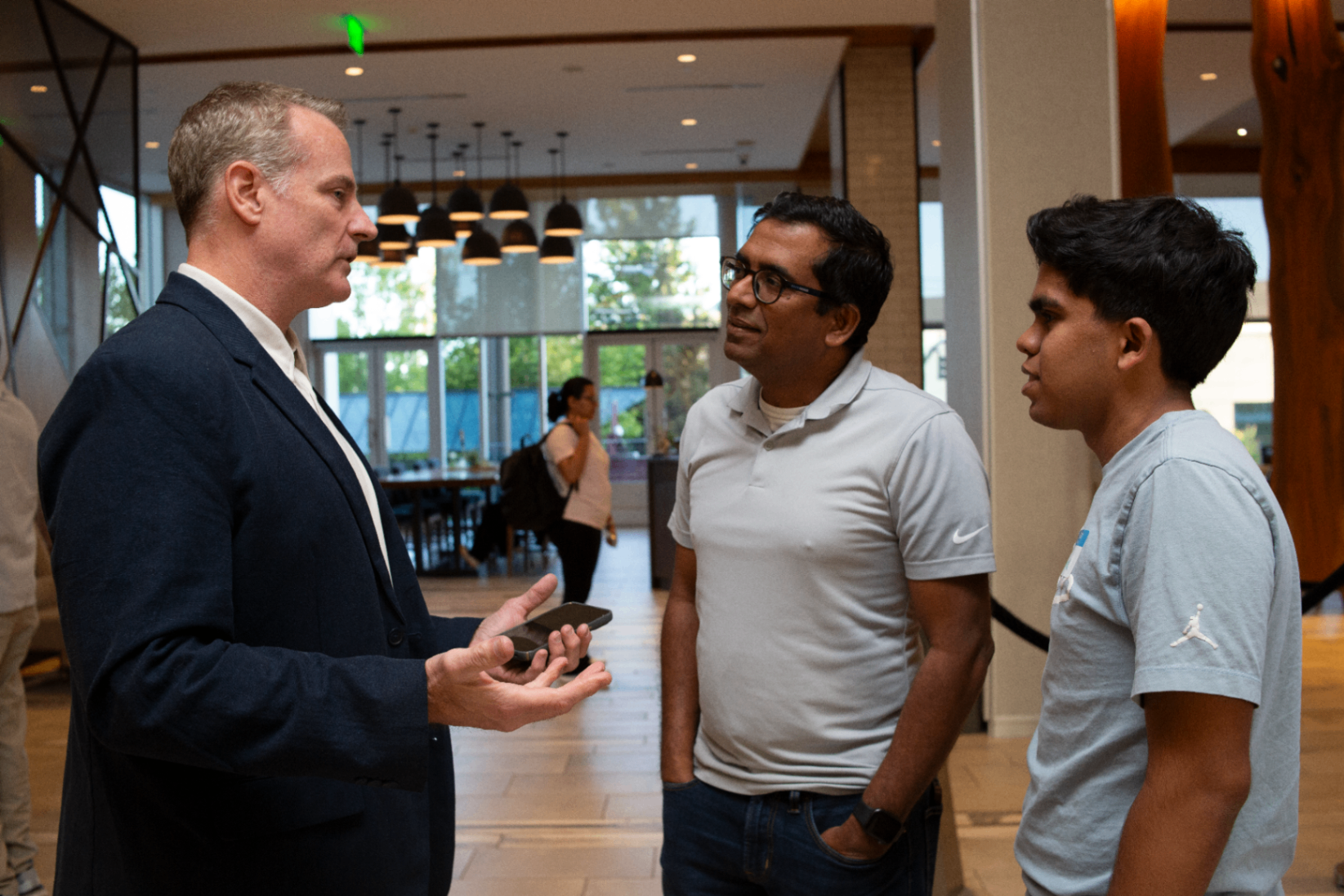Attendees in conversation in the bright lobby space